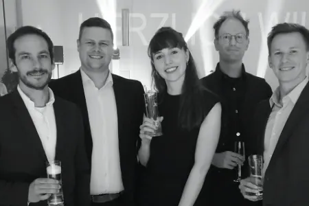 Fünf Personen stoßen bei der Gala des Salzburger Wirtschaftspreises WIKARUS mit Sektgläsern an.
